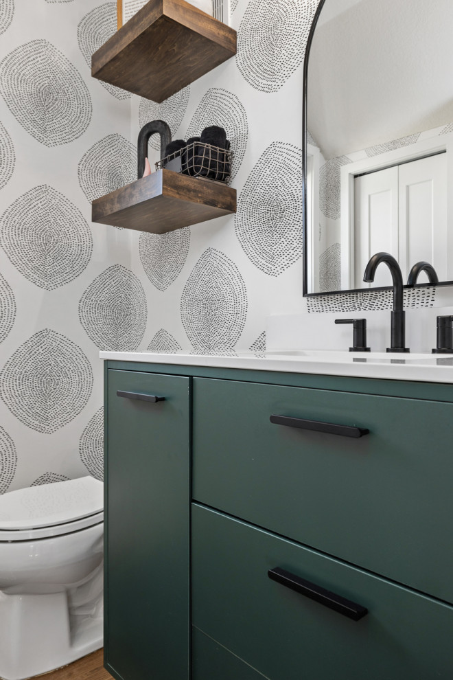 Photo of a small classic cloakroom in Other with flat-panel cabinets, green cabinets, a two-piece toilet, vinyl flooring, a submerged sink, engineered stone worktops, brown floors, white worktops, a freestanding vanity unit and wallpapered walls.