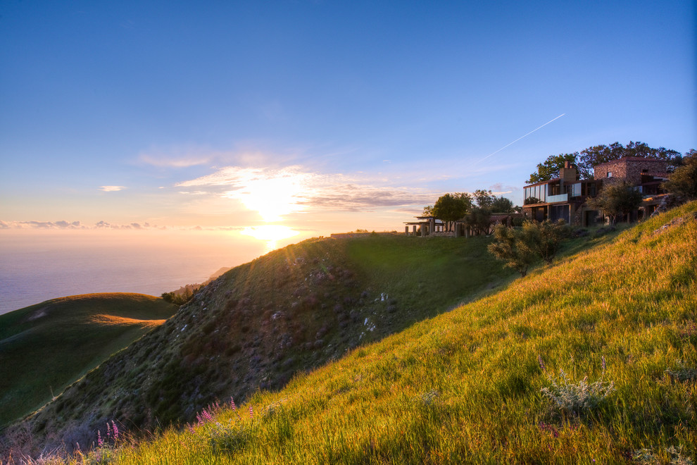 Big Sur Coast Ridge Estate - Breathtaking views of the incomparable Big Sur Coast, this classic Tuscan design of an Italian farmhouse, combined with a modern approach creates an ambiance of relaxed sophistication for this magnificent 95.73-acre, private coastal estate on California’s Coastal Ridge. Five-bedroom, 5.5-bath, 7,030 sq. ft. main house, and 864 sq. ft. caretaker house over 864 sq. ft. of garage and laundry facility. Commanding a ridge above the Pacific Ocean and Post Ranch Inn, this spectacular property has sweeping views of the California coastline and surrounding hills. “It’s as if a contemporary house were overlaid on a Tuscan farm-house ruin,” says decorator Craig Wright who created the interiors. The main residence was designed by renowned architect Mickey Muenning—the architect of Big Sur’s Post Ranch Inn, —who artfully combined the contemporary sensibility and the Tuscan vernacular, featuring vaulted ceilings, stained concrete floors, reclaimed Tuscan wood beams, antique Italian roof tiles and a stone tower. Beautifully designed for indoor/outdoor living; the grounds offer a plethora of comfortable and inviting places to lounge and enjoy the stunning views. No expense was spared in the construction of this exquisite estate.