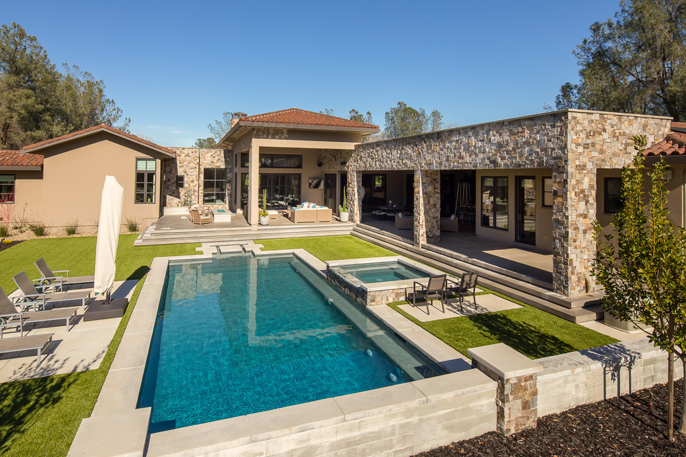 Mid-sized mediterranean backyard rectangular lap pool in Sacramento with a hot tub and concrete slab.