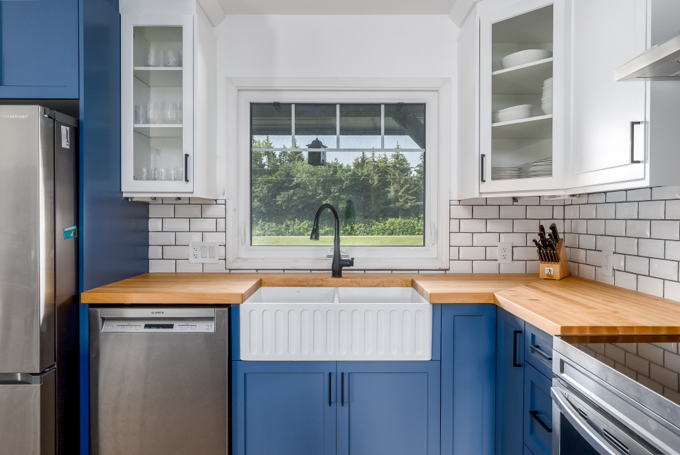 Inspiration for a transitional kitchen remodel in Edmonton with shaker cabinets, blue cabinets, quartzite countertops, subway tile backsplash, stainless steel appliances, an island and white countertops