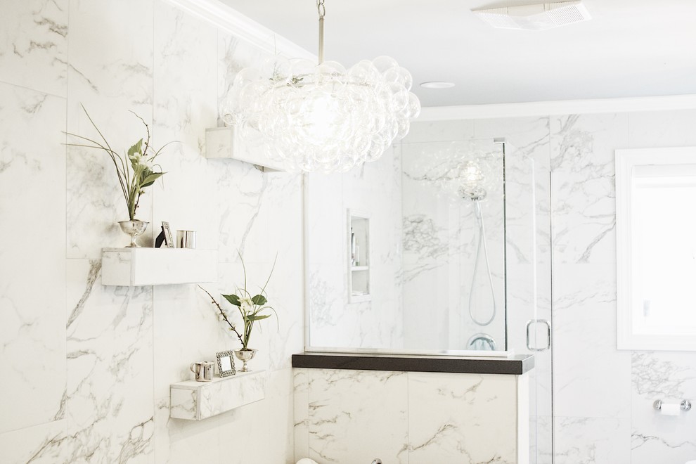 Example of a large transitional master gray tile, white tile and porcelain tile alcove shower design with shaker cabinets, white cabinets, a two-piece toilet, white walls, an undermount sink, solid surface countertops and a hinged shower door
