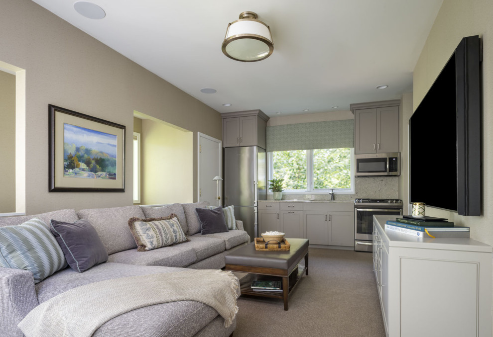 Imagen de sala de estar cerrada actual de tamaño medio sin chimenea con paredes beige, suelo de madera en tonos medios y televisor colgado en la pared