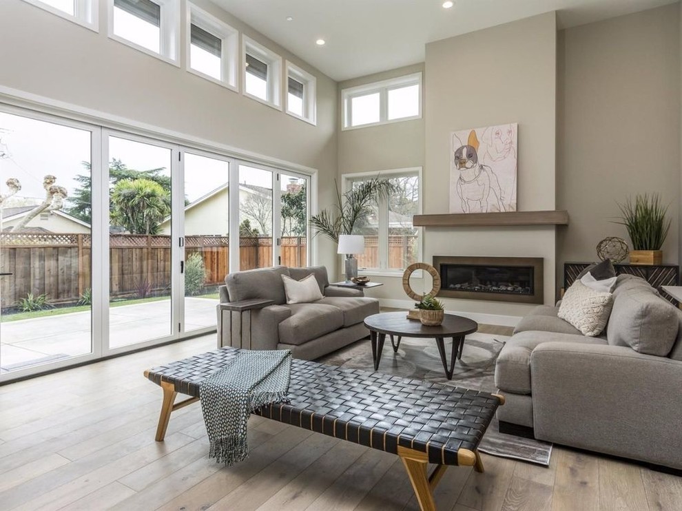 Inspiration for a large modern open concept living room in San Francisco with beige walls, light hardwood floors, a ribbon fireplace, a metal fireplace surround, no tv and brown floor.