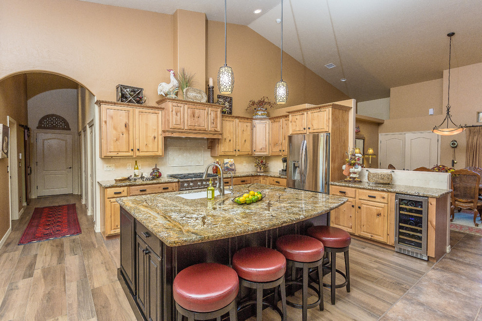 Eat-in kitchen - large transitional l-shaped dark wood floor and brown floor eat-in kitchen idea in Phoenix with an undermount sink, raised-panel cabinets, light wood cabinets, granite countertops, beige backsplash, stainless steel appliances and an island