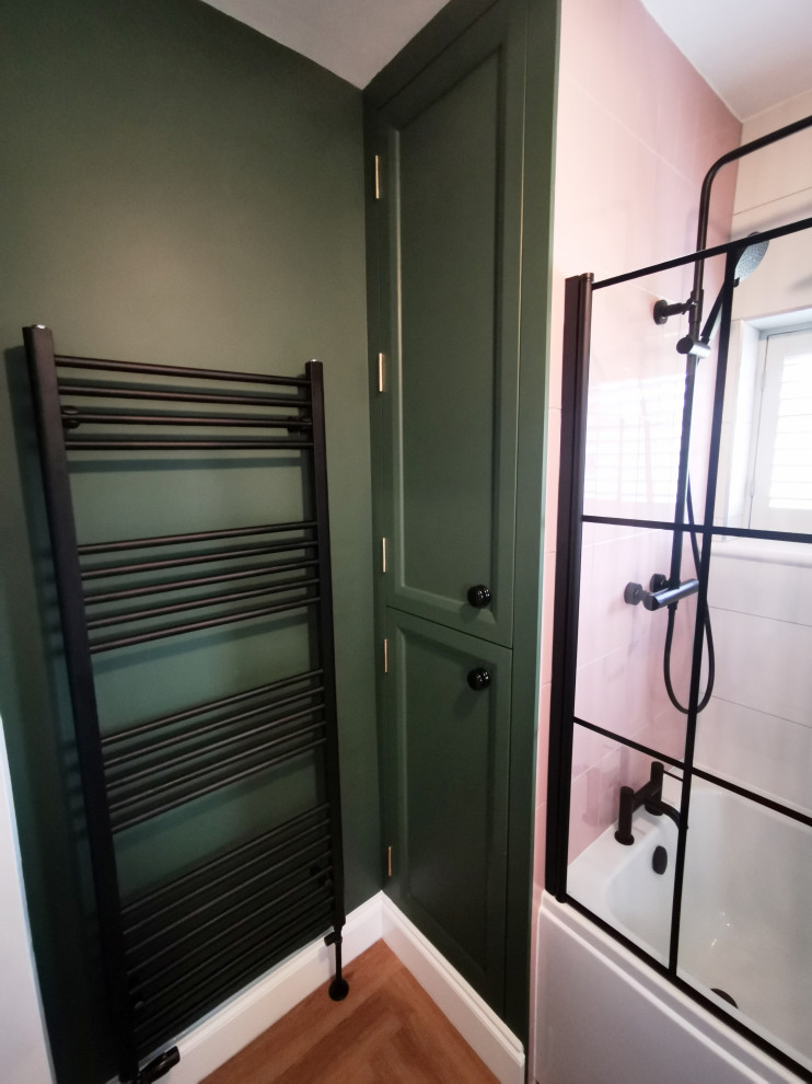 На фото: детская ванная комната среднего размера в классическом стиле с плоскими фасадами, синими фасадами, накладной ванной, душем над ванной, унитазом-моноблоком, розовой плиткой, керамической плиткой, зелеными стенами, полом из винила, столешницей из искусственного кварца, белой столешницей, тумбой под одну раковину и напольной тумбой