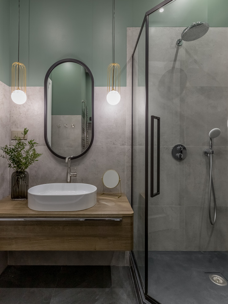 Inspiration för mellanstora moderna beige en-suite badrum, med möbel-liknande, en hörndusch, grå kakel, keramikplattor, gröna väggar, ett fristående handfat, laminatbänkskiva, svart golv och skåp i mellenmörkt trä