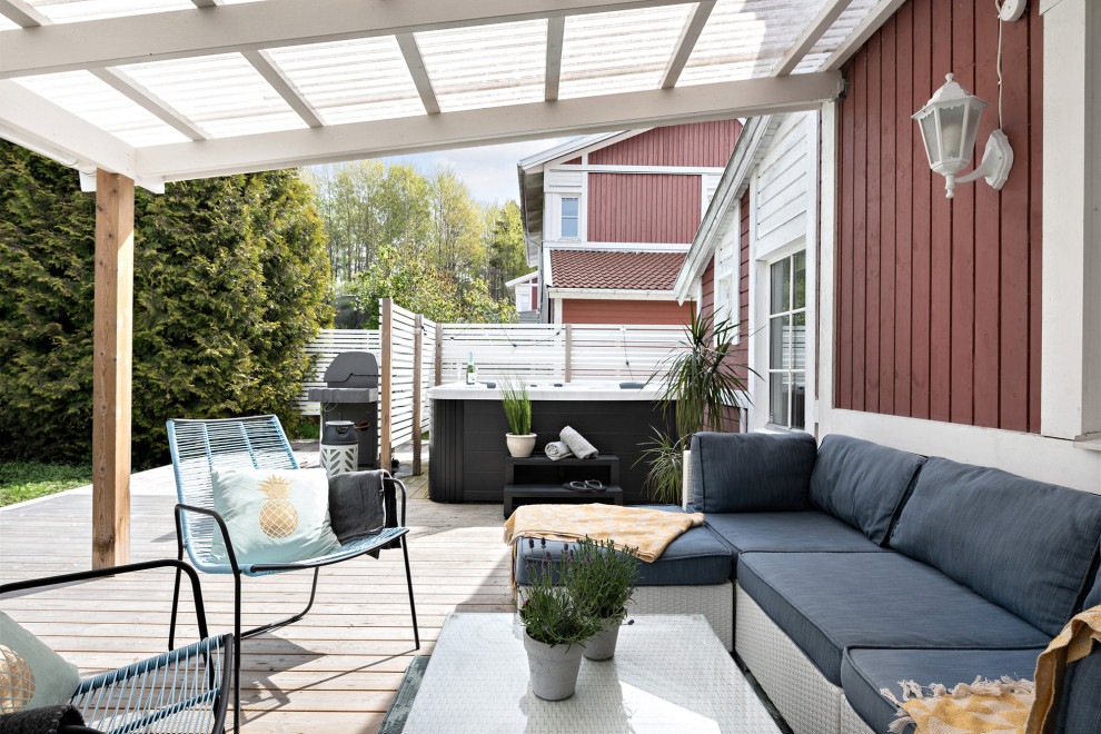 Photo of a large scandinavian backyard deck in Stockholm with a pergola.