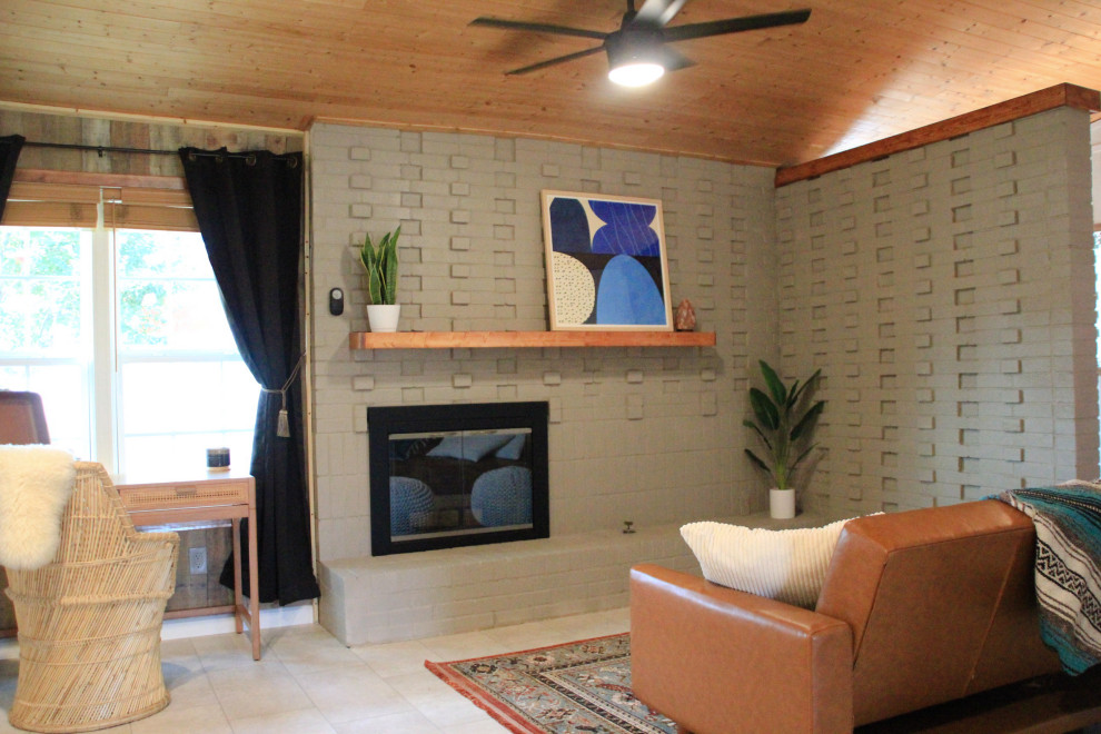Aménagement d'un salon rétro de taille moyenne et ouvert avec un mur gris, une cheminée standard, un manteau de cheminée en brique, un sol beige, un plafond en bois et du lambris.