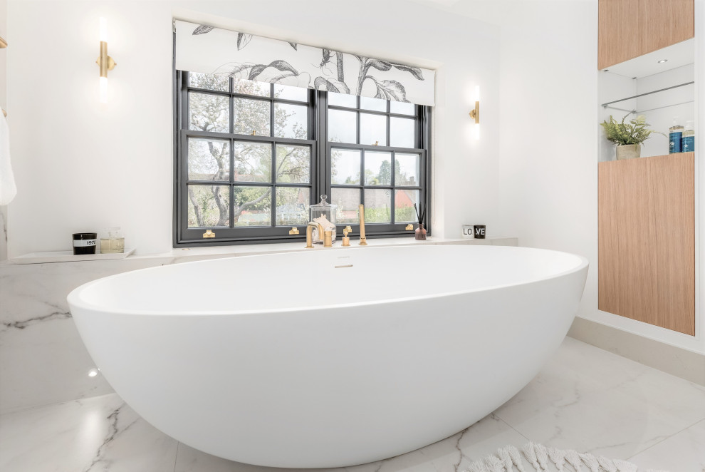 На фото: большая главная, серо-белая ванная комната в стиле модернизм с плоскими фасадами, светлыми деревянными фасадами, отдельно стоящей ванной, открытым душем, инсталляцией, белой плиткой, керамогранитной плиткой, белыми стенами, полом из керамогранита, подвесной раковиной, столешницей из кварцита, белым полом, открытым душем, белой столешницей, сиденьем для душа, тумбой под две раковины, подвесной тумбой и сводчатым потолком