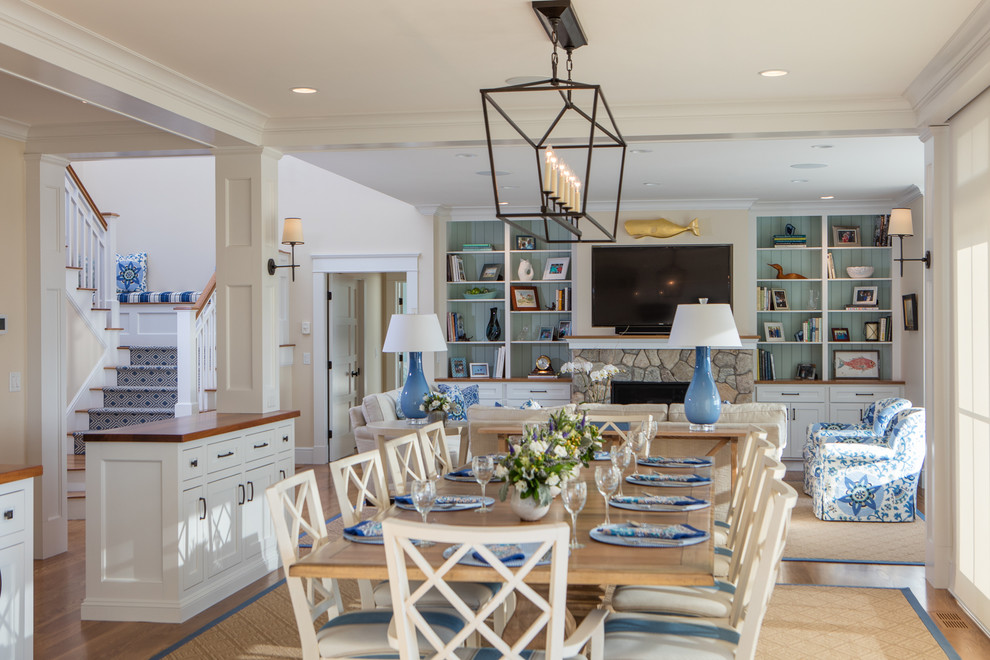 Large beach style open plan dining in Boston with beige walls, medium hardwood floors, a standard fireplace, a stone fireplace surround and brown floor.