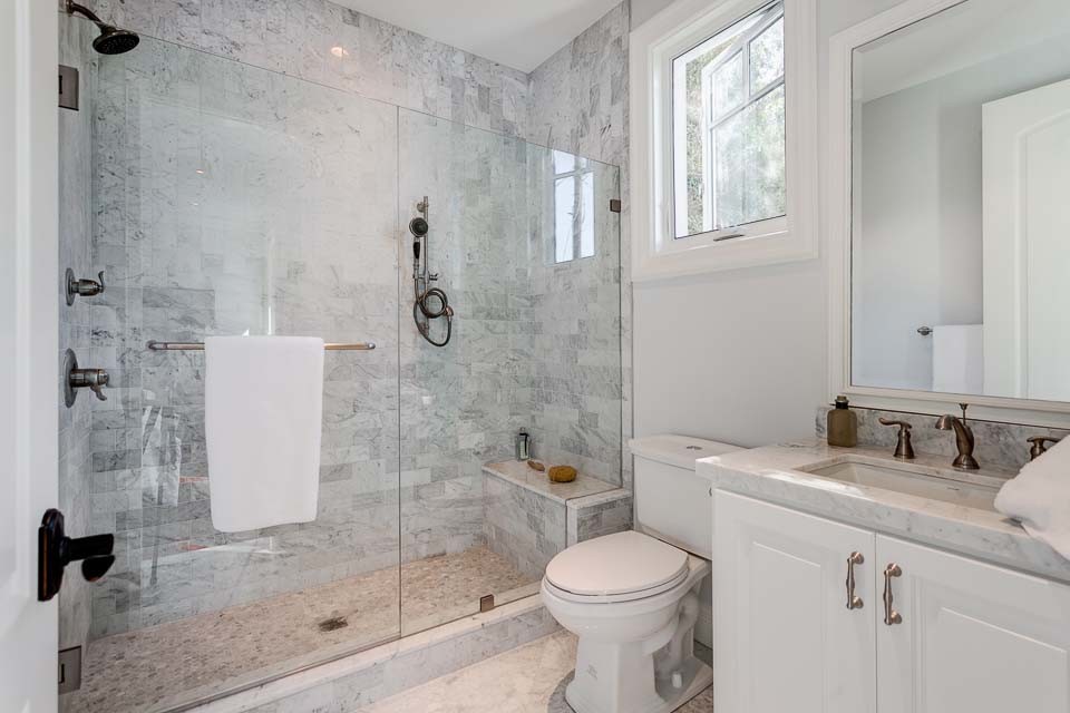 Large transitional kids bathroom in Brisbane with an undermount sink, raised-panel cabinets, white cabinets, marble benchtops, a drop-in tub, a corner shower, gray tile, stone tile, grey walls and marble floors.