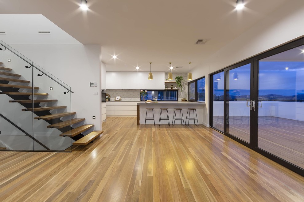 Inspiration for a mid-sized modern open concept family room in Canberra - Queanbeyan with medium hardwood floors.