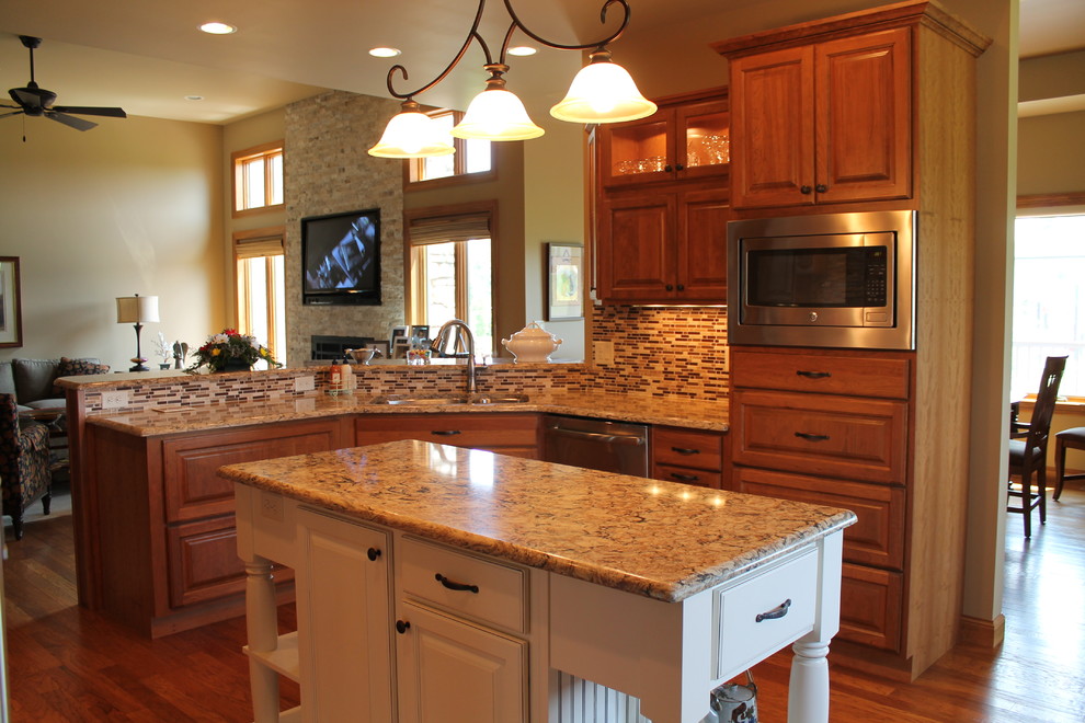 Inspiration for a large single-wall eat-in kitchen remodel with an undermount sink, raised-panel cabinets, medium tone wood cabinets, solid surface countertops, stainless steel appliances, beige walls and an island