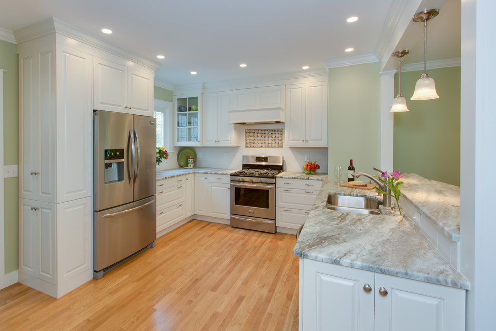 Example of a transitional u-shaped medium tone wood floor eat-in kitchen design in Boston with an undermount sink, raised-panel cabinets, white cabinets, granite countertops, white backsplash, subway tile backsplash and stainless steel appliances