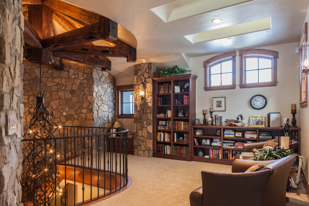 Photo of a country loft-style living room in Denver with a library, carpet and no tv.