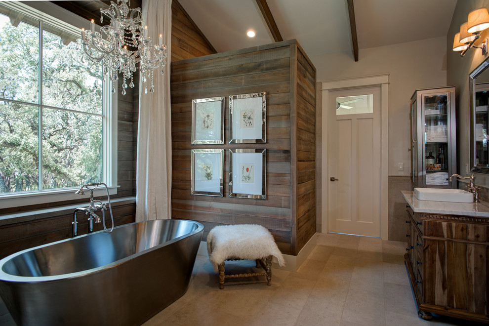 Photo of a country bathroom in Austin with a drop-in sink, dark wood cabinets, a freestanding tub, grey walls and recessed-panel cabinets.