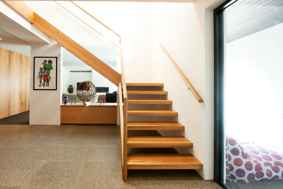 Aménagement d'un grand escalier sans contremarche moderne en L avec des marches en bois.