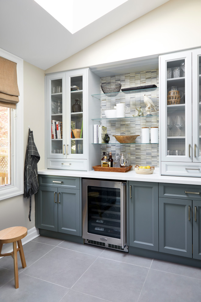 Medium sized traditional galley kitchen pantry in Toronto with a submerged sink, shaker cabinets, grey cabinets, engineered stone countertops, multi-coloured splashback, marble splashback, integrated appliances, porcelain flooring, a breakfast bar, grey floors and white worktops.