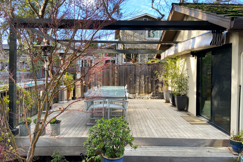 Photo of a mid-sized modern backyard and ground level deck in San Francisco with a pergola and wood railing.