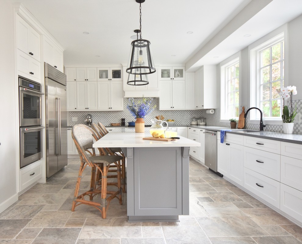 Photo of a transitional u-shaped kitchen in DC Metro with an undermount sink, shaker cabinets, white cabinets, grey splashback, stainless steel appliances, with island, beige floor and grey benchtop.
