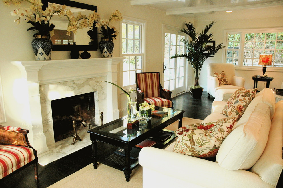 This is an example of a traditional living room in Los Angeles with beige walls and a standard fireplace.