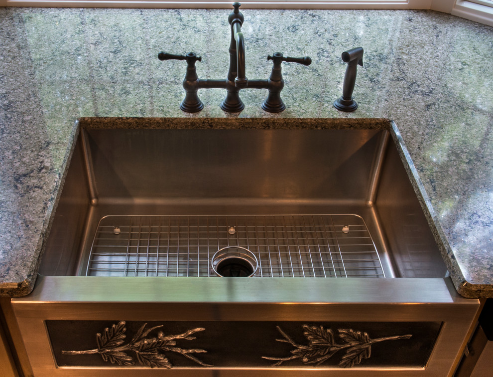 Inspiration for a mid-sized rustic u-shaped medium tone wood floor enclosed kitchen remodel with a farmhouse sink, shaker cabinets, medium tone wood cabinets, granite countertops, beige backsplash, ceramic backsplash, stainless steel appliances and an island