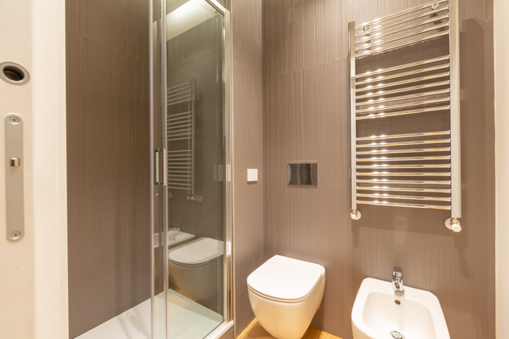 Diseño de aseo moderno con sanitario de pared, suelo de madera clara, lavabo con pedestal, suelo amarillo y bandeja