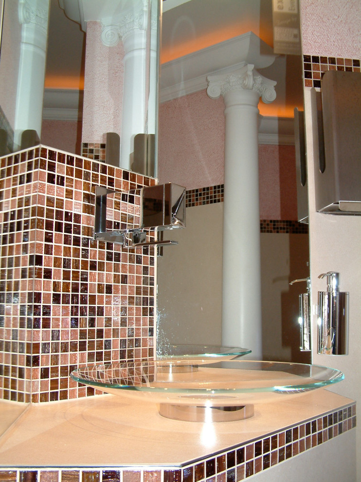 Foto på ett stort vintage beige toalett, med en vägghängd toalettstol, brun kakel, glaskakel, beige väggar, linoleumgolv, ett fristående handfat, bänkskiva i glas och orange golv