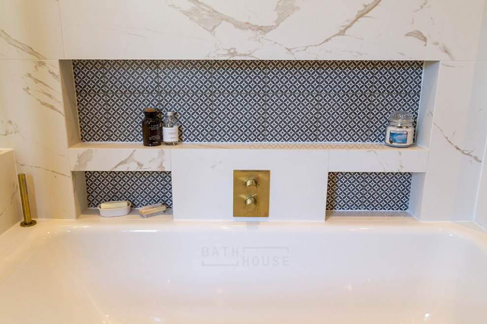 Источник вдохновения для домашнего уюта: главная ванная комната среднего размера в стиле неоклассика (современная классика) с фасадами островного типа, синими фасадами, накладной ванной, душевой комнатой, инсталляцией, белой плиткой, керамической плиткой, белыми стенами, полом из керамической плитки, монолитной раковиной, столешницей из искусственного камня, коричневым полом, открытым душем, белой столешницей, тумбой под одну раковину и встроенной тумбой