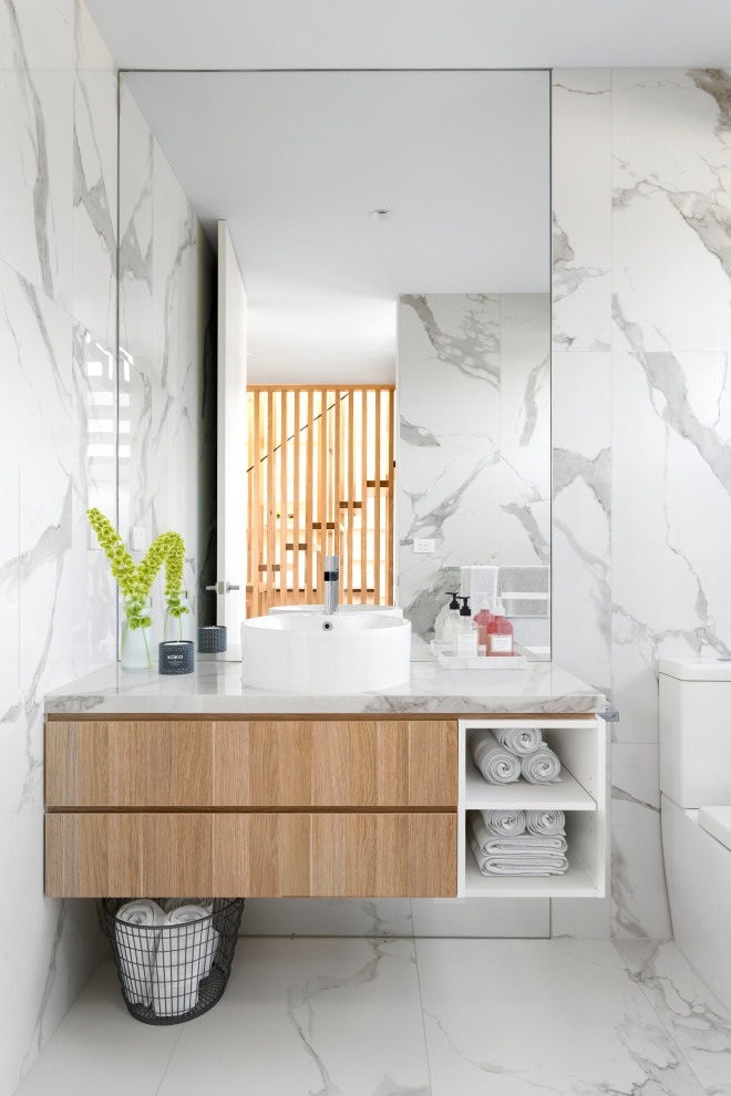 This is an example of a mid-sized contemporary master bathroom in Melbourne with light wood cabinets, an open shower, white tile, marble, white walls, marble floors, a vessel sink, marble benchtops, white floor, a double vanity, a floating vanity, a corner tub and flat-panel cabinets.