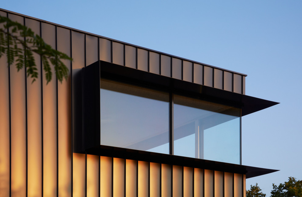 Inspiration for a large contemporary two-storey black house exterior in Melbourne with metal siding and a grey roof.