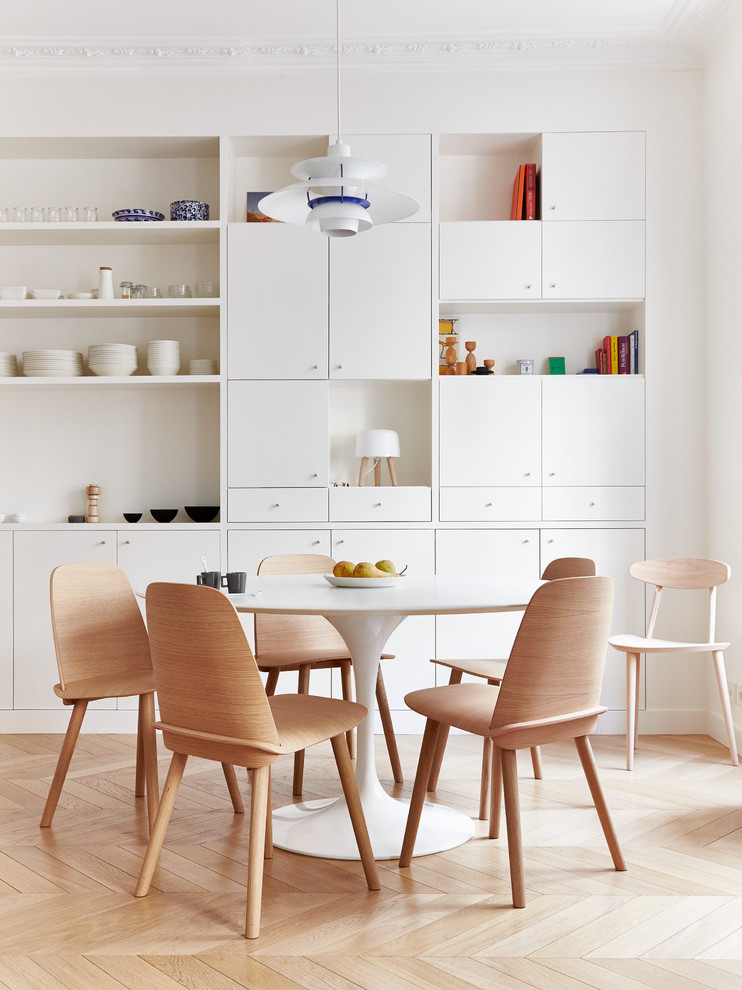 Photo of a mid-sized scandinavian dining room in Paris with light hardwood floors and white walls.