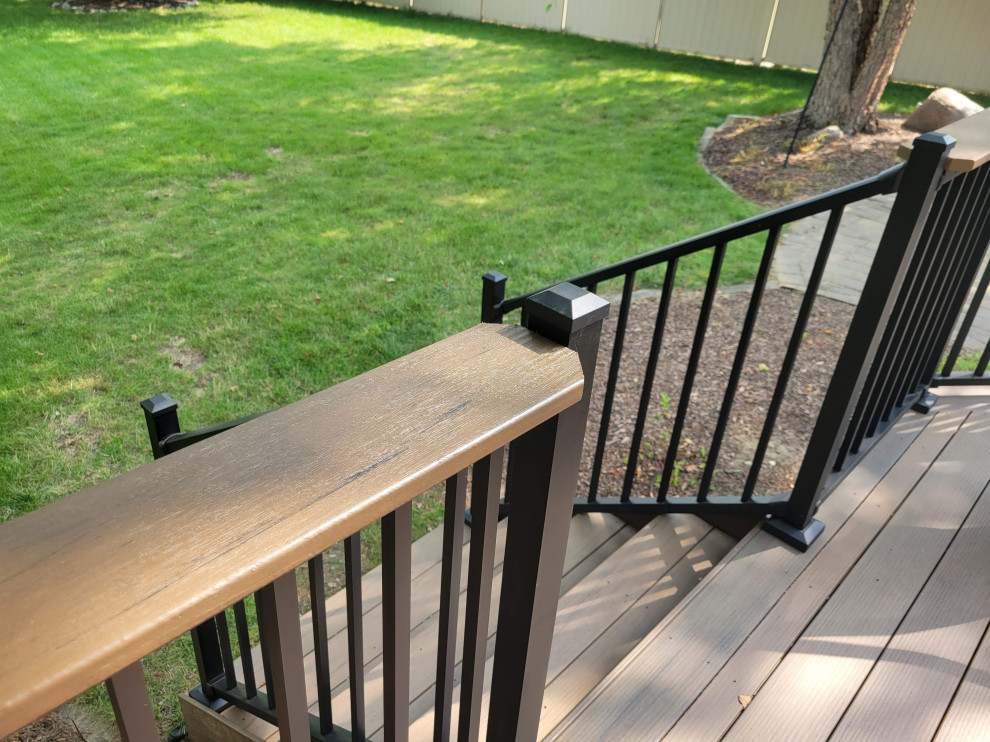 Imagen de terraza planta baja tradicional de tamaño medio sin cubierta en patio trasero con barandilla de metal