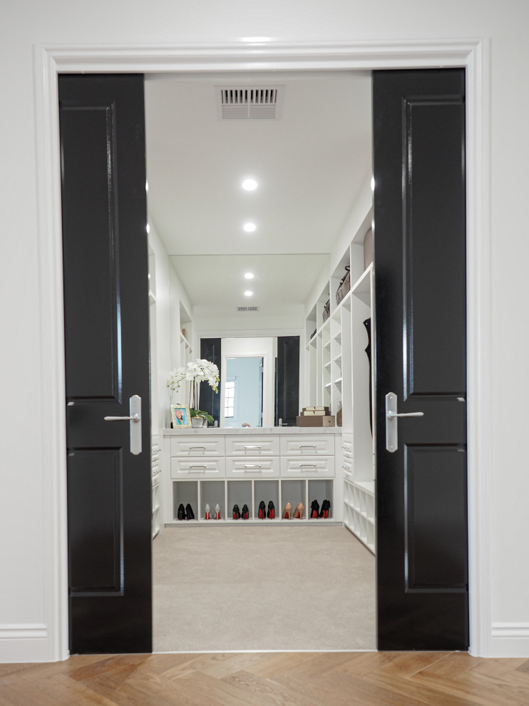 Photo of a small contemporary walk-in wardrobe in Brisbane with shaker cabinets, white cabinets and carpet.