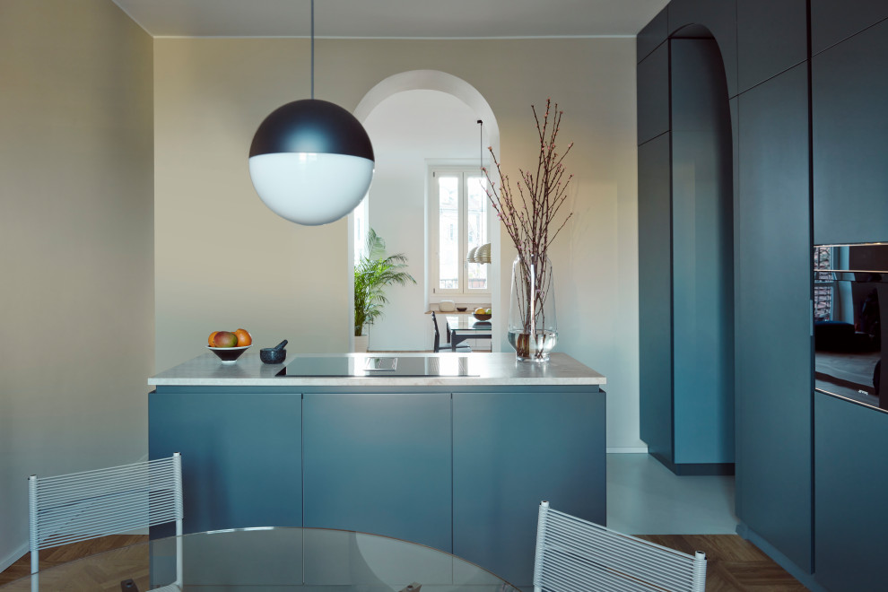 Idées déco pour une cuisine contemporaine de taille moyenne avec un évier encastré, des portes de placard bleues, plan de travail en marbre, une crédence en marbre et îlot.