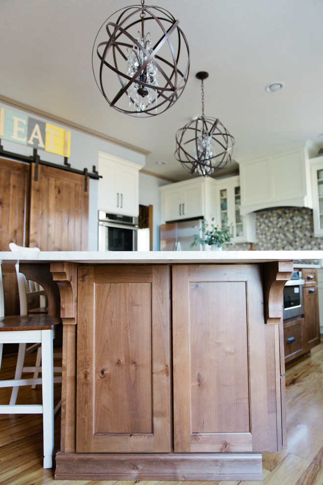 Large transitional u-shaped light wood floor eat-in kitchen photo in Denver with a farmhouse sink, shaker cabinets, white cabinets, quartz countertops, multicolored backsplash, porcelain backsplash, stainless steel appliances and an island