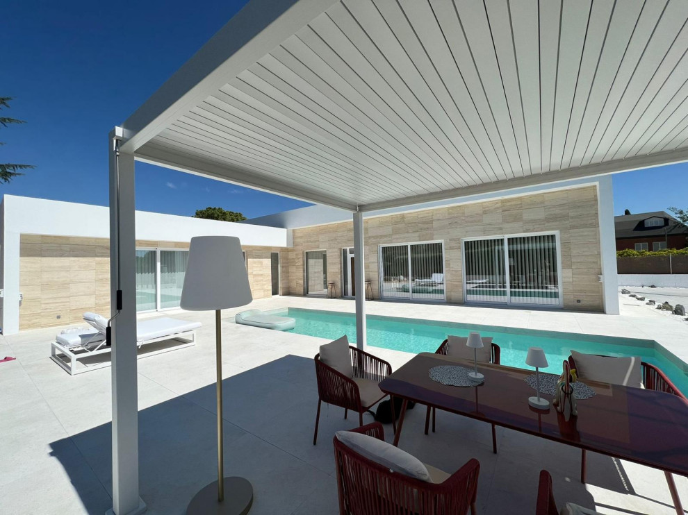 Imagen de patio actual de tamaño medio en patio lateral con ducha exterior, suelo de baldosas y pérgola