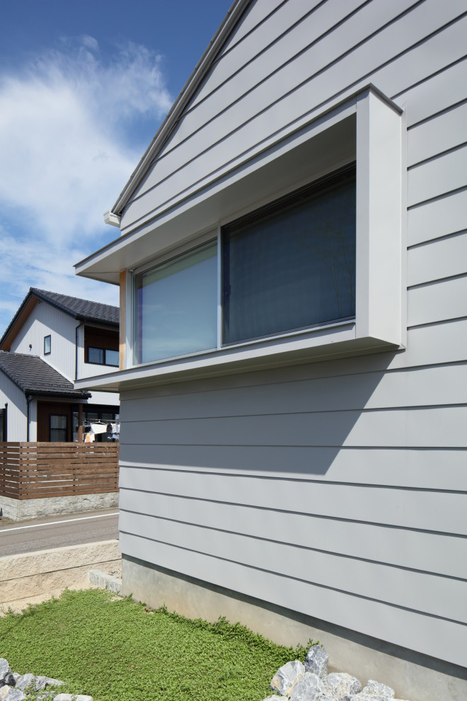 Imagen de fachada de casa gris y gris moderna de una planta con tejado a dos aguas y tejado de metal