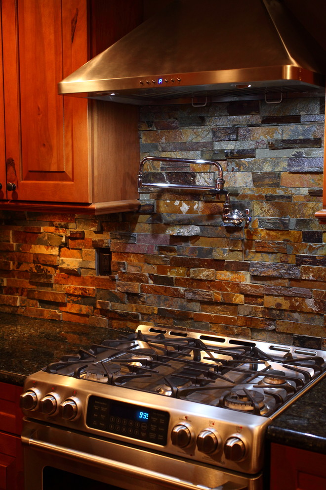 Inspiration for a small rustic u-shaped eat-in kitchen remodel with a single-bowl sink, raised-panel cabinets, medium tone wood cabinets, granite countertops, multicolored backsplash, stone slab backsplash, stainless steel appliances and no island