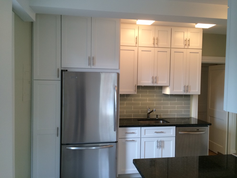Enclosed kitchen - mid-sized transitional u-shaped porcelain tile enclosed kitchen idea in Orange County with an undermount sink, shaker cabinets, white cabinets, granite countertops, gray backsplash, ceramic backsplash, stainless steel appliances and no island