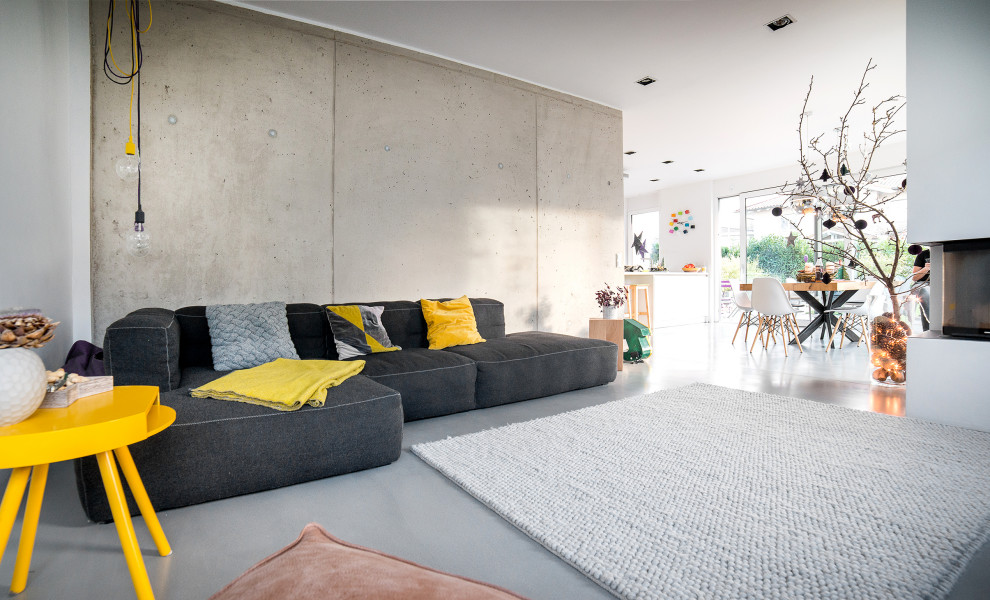 This is an example of a contemporary open concept living room in Other with grey walls, concrete floors and grey floor.