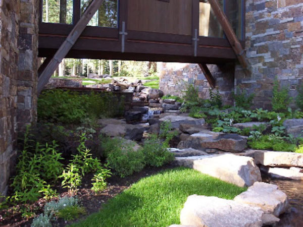 This is an example of a huge rustic full sun backyard stone water fountain landscape in Denver.