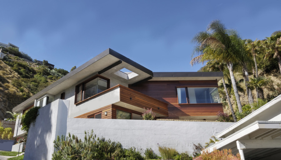 Design ideas for a large contemporary split-level stucco grey exterior in Los Angeles with a clipped gable roof.