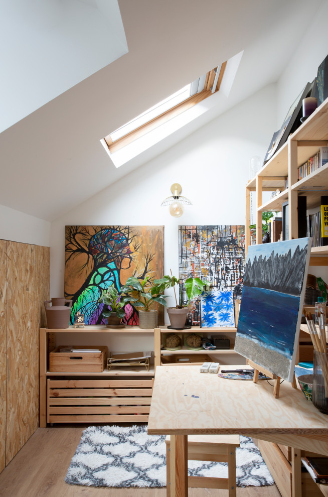 Idéer för ett modernt arbetsrum, med vita väggar, ljust trägolv, ett inbyggt skrivbord och beiget golv