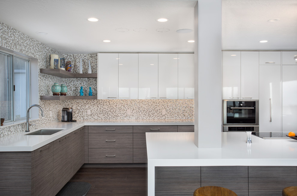 Large contemporary l-shaped eat-in kitchen in Salt Lake City with an undermount sink, flat-panel cabinets, beige splashback, mosaic tile splashback, stainless steel appliances, dark hardwood floors, with island, brown floor, white cabinets and quartzite benchtops.