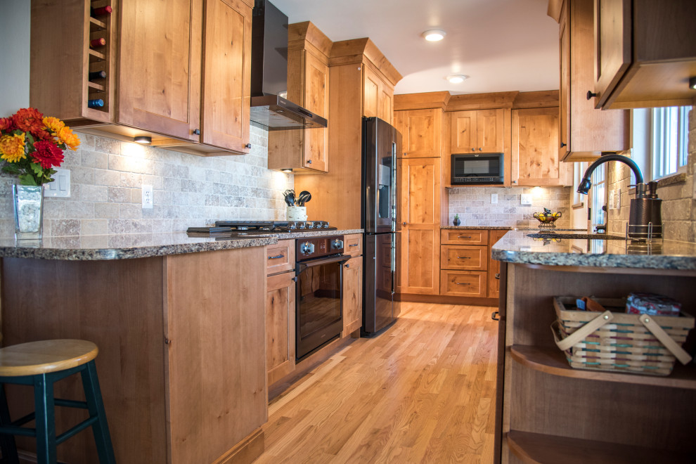 Inspiration for a mid-sized rustic galley medium tone wood floor and brown floor eat-in kitchen remodel in Denver with an undermount sink, shaker cabinets, medium tone wood cabinets, quartz countertops, gray backsplash, stone tile backsplash, black appliances, no island and brown countertops