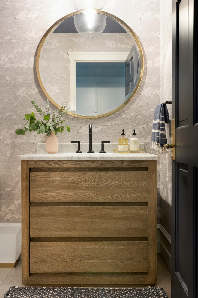 Inspiration for a large transitional powder room in Minneapolis with furniture-like cabinets, light wood cabinets, a one-piece toilet, porcelain floors, an undermount sink, marble benchtops, grey floor and white benchtops.