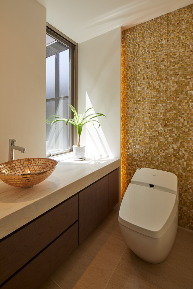 Modern powder room in Tokyo with flat-panel cabinets, grey cabinets, yellow tile, white walls, a vessel sink, brown floor and beige benchtops.