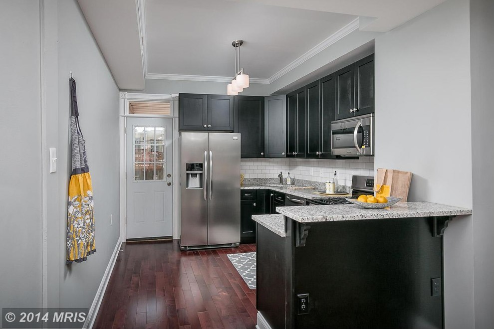 Eat-in kitchen - small modern single-wall dark wood floor eat-in kitchen idea in Baltimore with an undermount sink, shaker cabinets, black cabinets, granite countertops, white backsplash, ceramic backsplash, stainless steel appliances and an island