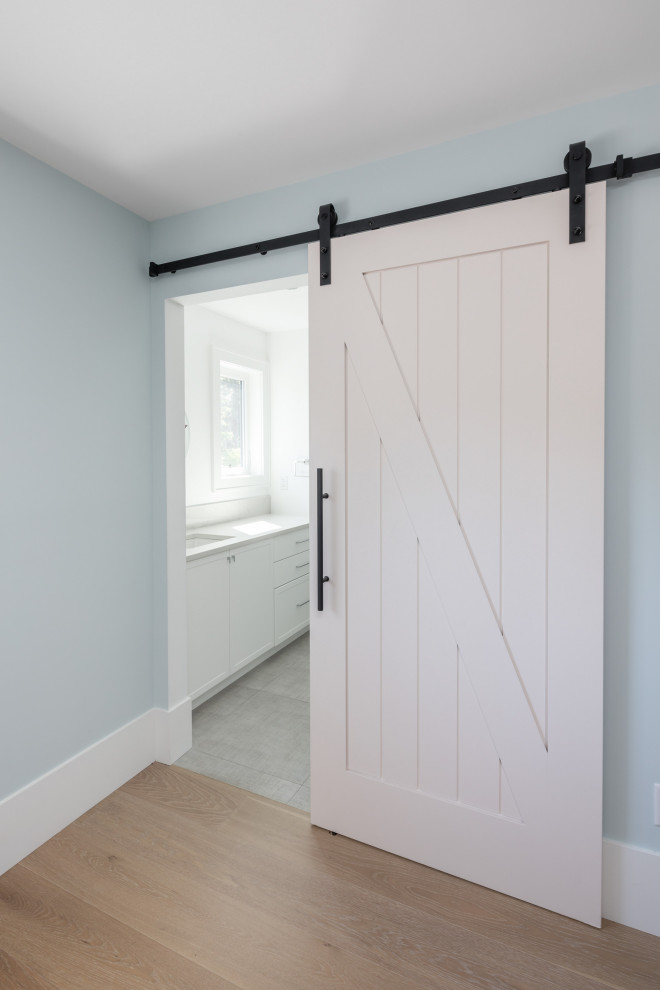 Стильный дизайн: узкая прихожая среднего размера в стиле кантри с синими стенами, светлым паркетным полом, раздвижной входной дверью, белой входной дверью и бежевым полом - последний тренд